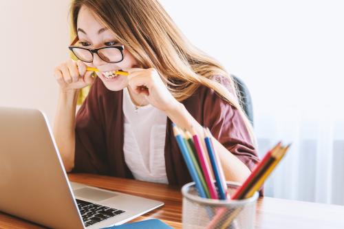 A woman biting a pencil in anger