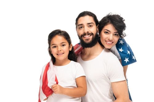 A happy family smiling while covered with an American flag